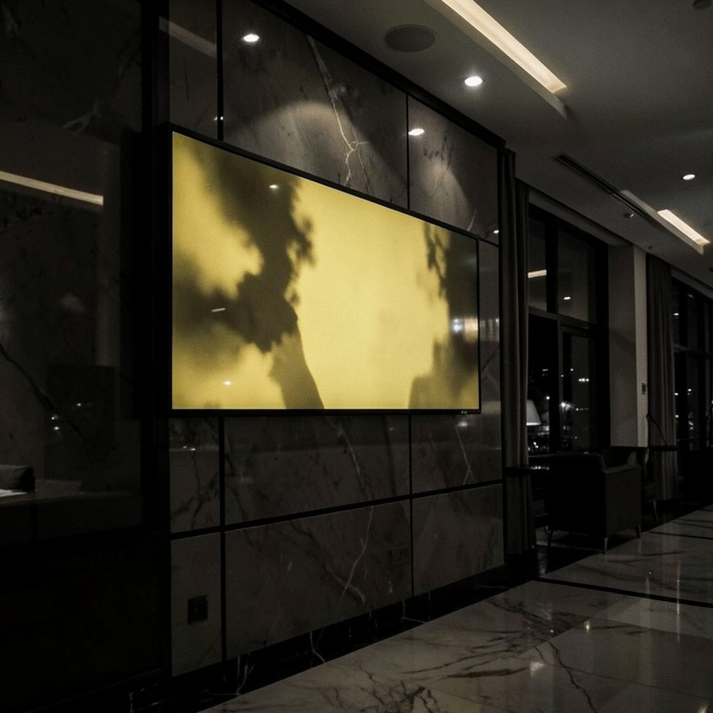 صورة ثنائية اللون لشاشة LED مثبتة على واجهة فندق فاخر ليلاً، ألوان داكنة مع تباين ذهبي دافئ
